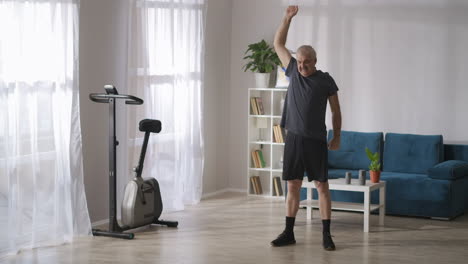 elderly-man-is-doing-gymnastics-in-his-apartment-at-sunday-morning-caring-about-health-of-joints-breathing-exercises